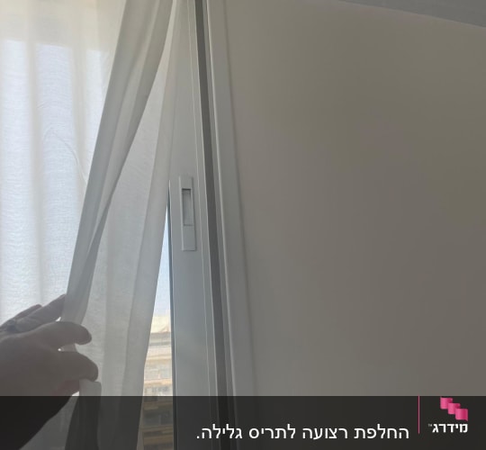 תריסים לבנים ליד חלון עם וילון לבן